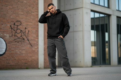 Model wearing TWLV02 black hoodie in urban street setting